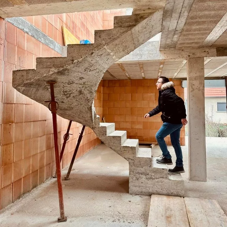 Thibaut, conducteur de travaux chez Maisons Crisalis, monte l’escalier d’une maison en construction