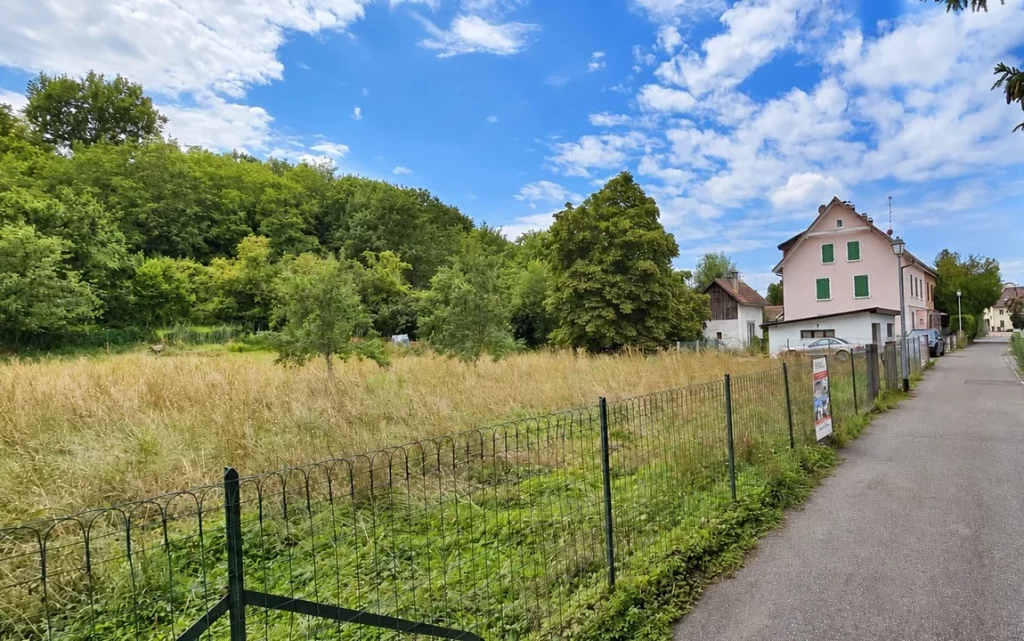 Terrain clôturé bordant une rue résidentielle dans le Haut-Rhin